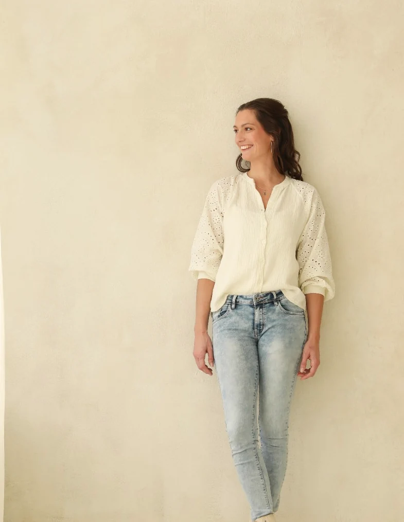Irene Hoving in een lichte blouse en spijkerbroek